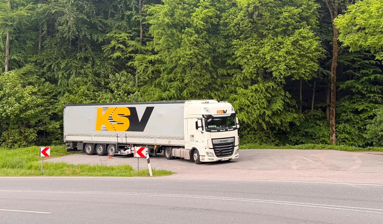 Orman kenarında beyaz KSV DAF çekici ve logolu dorse